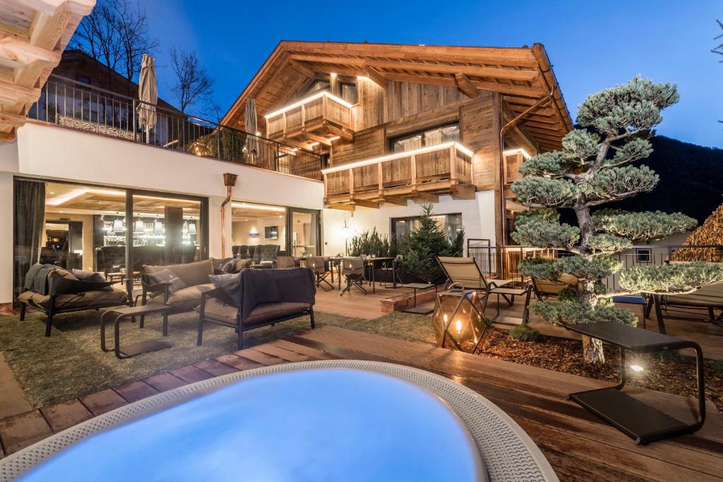 een huis met een hot tub in de tuin bij Hotel Montchalet in Ortisei