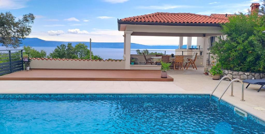 a swimming pool in front of a house with a gazebo at ISTRIAN vibeS in Drenje