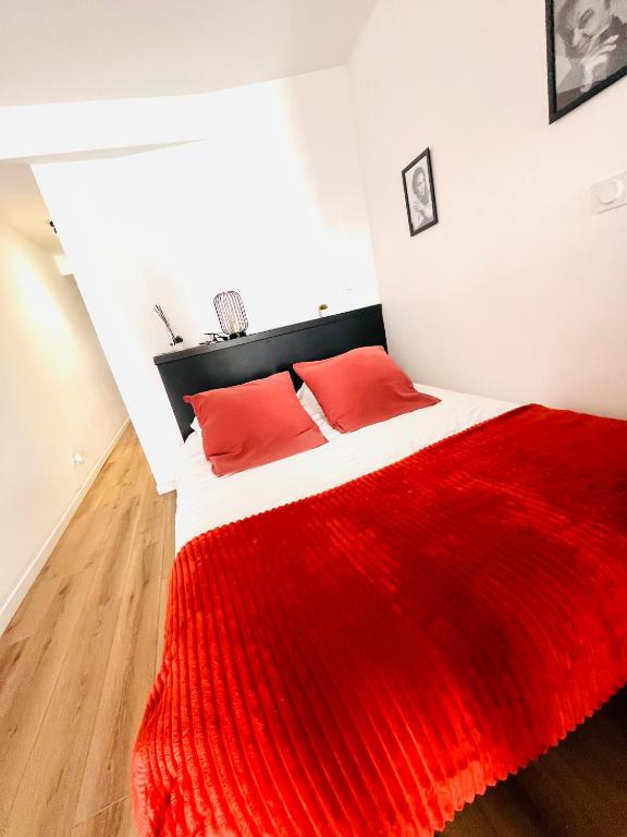 a bedroom with a red blanket on a bed at Le studio terrasse Béthunois - Appart hôtel centre climatisé - All confort in Béthune