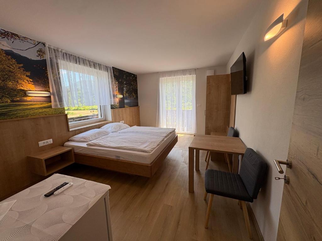 a bedroom with a bed and a table and a chair at Guesthouse Ema in Bohinj