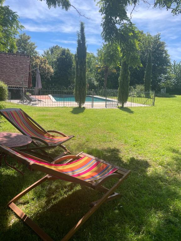 a deck chair sitting in the grass near a pool at La MaiZon in Lazenay
