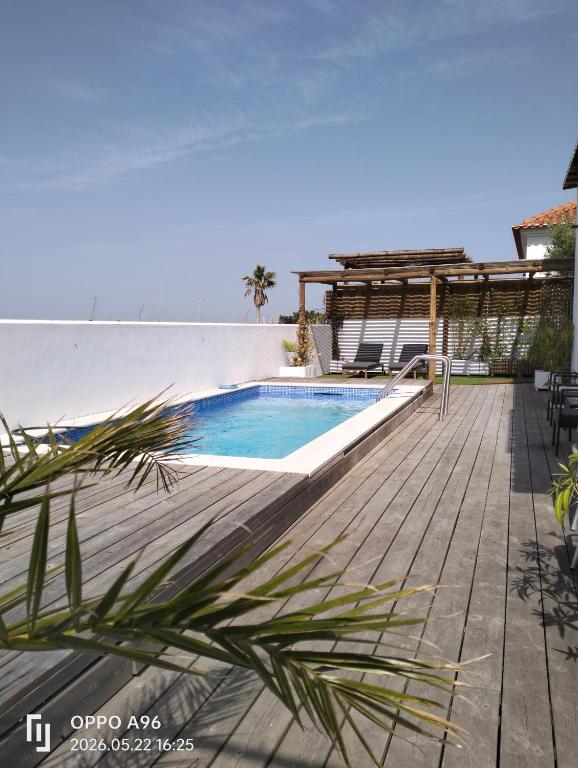 a swimming pool on a deck next to a house at Paradise Breeze in Carvalhal