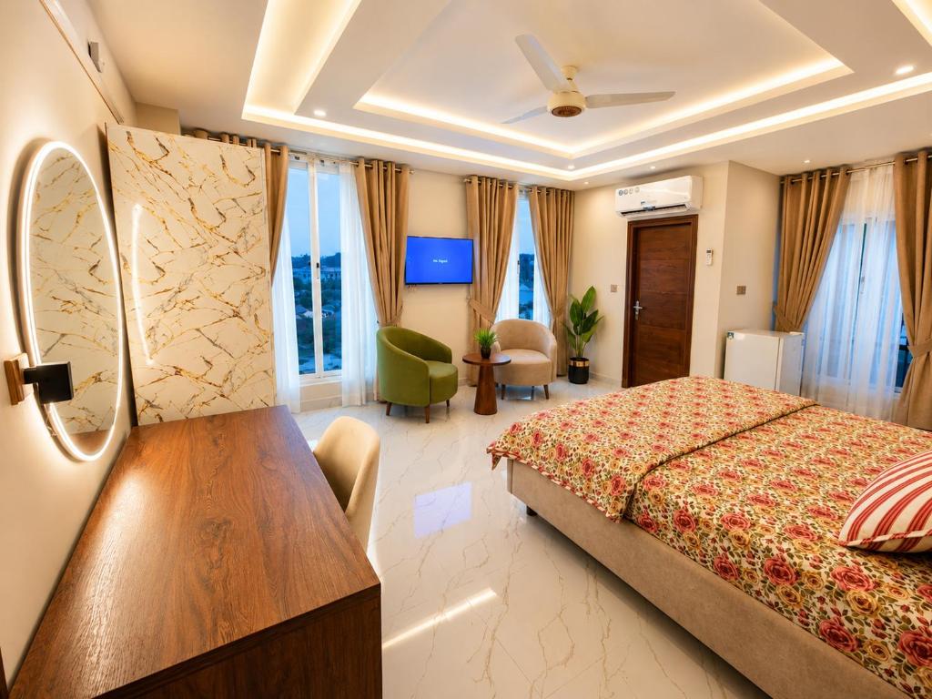 a hotel room with a bed and a desk in it at Motorway Majesty Heights - Near Islamabad International Airport and Motorway in Islamabad