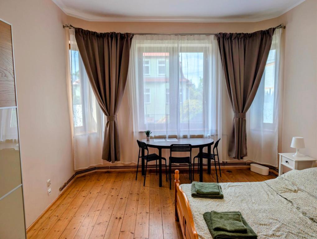 a bedroom with a table and a dining room at Hostel Kalinowskiego in Żary