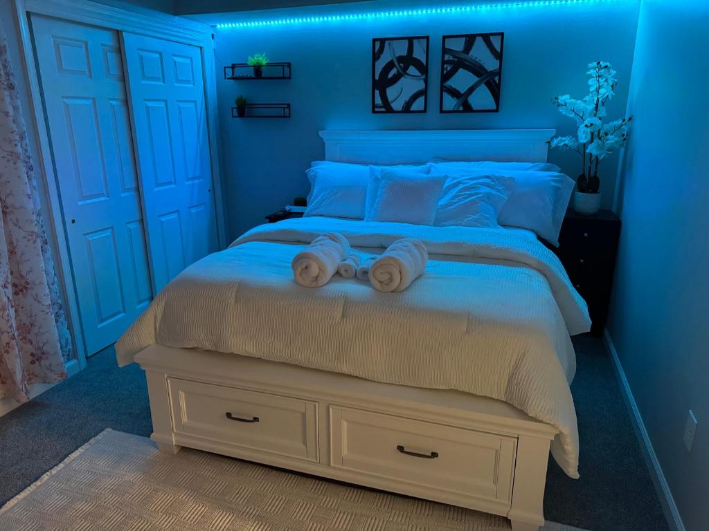 ein blaues Schlafzimmer mit einem Bett, auf dem zwei Handtücher liegen in der Unterkunft Raqsea Condo in Hampton