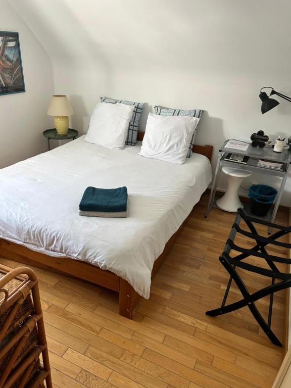 a bedroom with a bed with a blue towel on it at Le Korrigan in Saint-Jacques-de-la-Lande