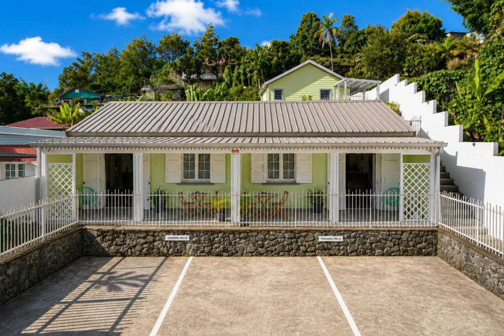 a house with a tennis court in front of it at Lacaze Salazie in Hell-Bourg