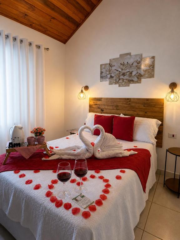 a bedroom with two swans with wine glasses on a bed at Casa da Vovó na Pousada Sitio Pauletto - com Cozinha, Churrasqueira e Decoração in Jarinu