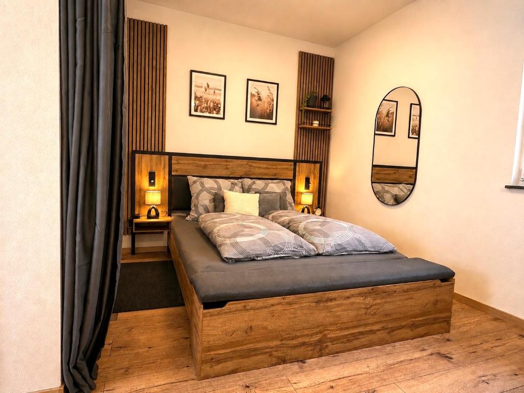 a bedroom with a wooden bed with a mirror at Ferienhaus Lenz in Kalenborn