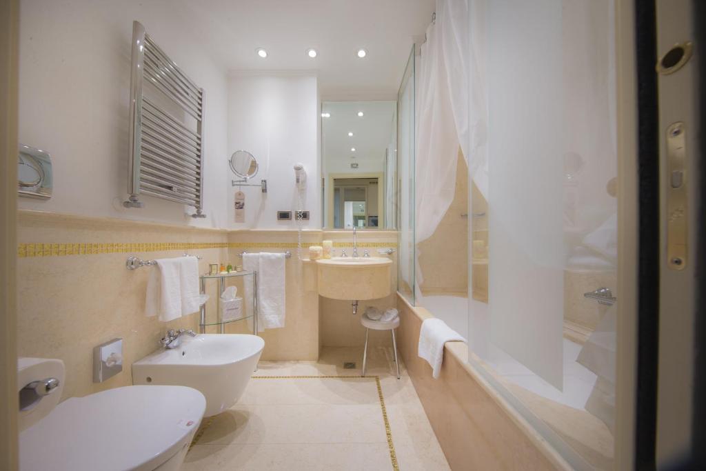 a bathroom with a sink and a toilet and a shower at Hotel A La Commedia in Venice