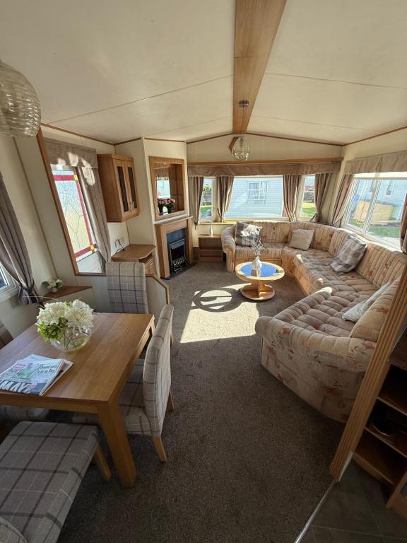 a living room with a couch and a table at Jemmas Holiday Home in Arbroath