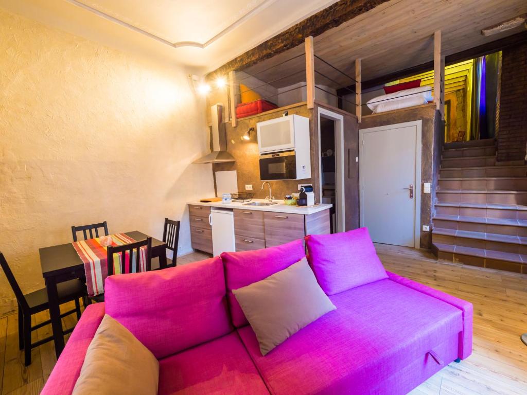 a living room with a purple couch and a kitchen at El Mercadal in Cardona