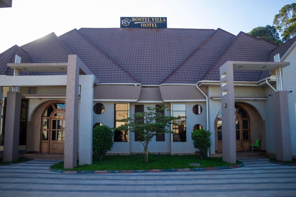 a building with a sign on top of it at Rostel Villa Hotel in Mbeya