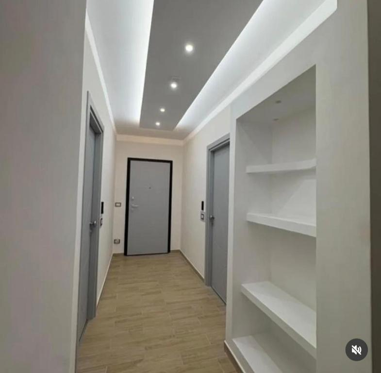 a hallway with white walls and shelves and a door at B&b Antonia in SantʼAntonio Abate