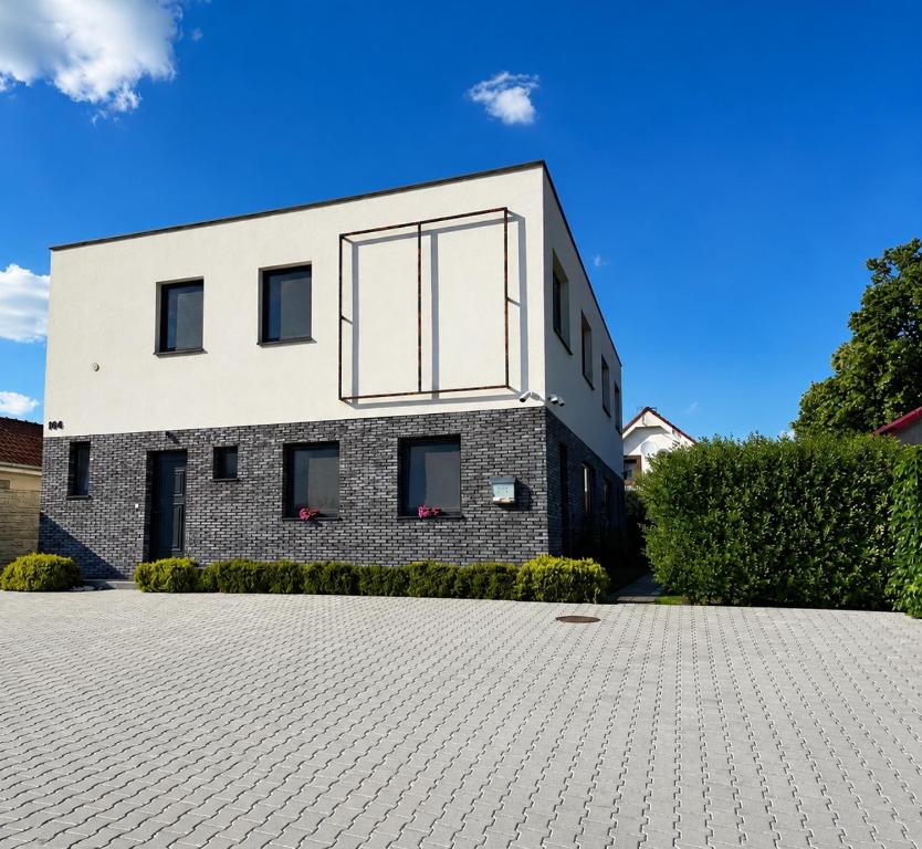 a brick house with large windows on a driveway at Luxury Private Apartment in Horná Potôň