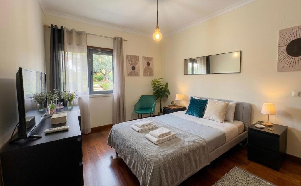 a bedroom with a bed and a desk and a television at To Be Apartments in Bobadela
