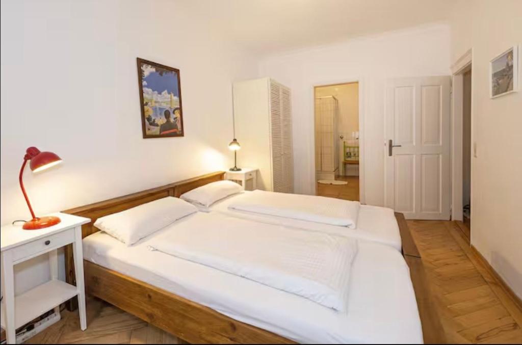 a bedroom with a large white bed and a lamp at FeWo3 in Lindau