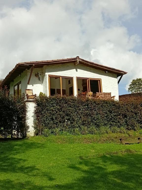 a small white house with a green yard at Alma de Acero in Envigado