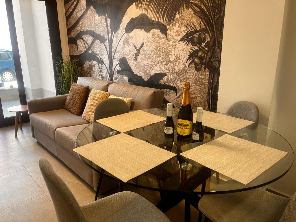 a living room with a table and two bottles of wine at Roque Home Stay in La Mata