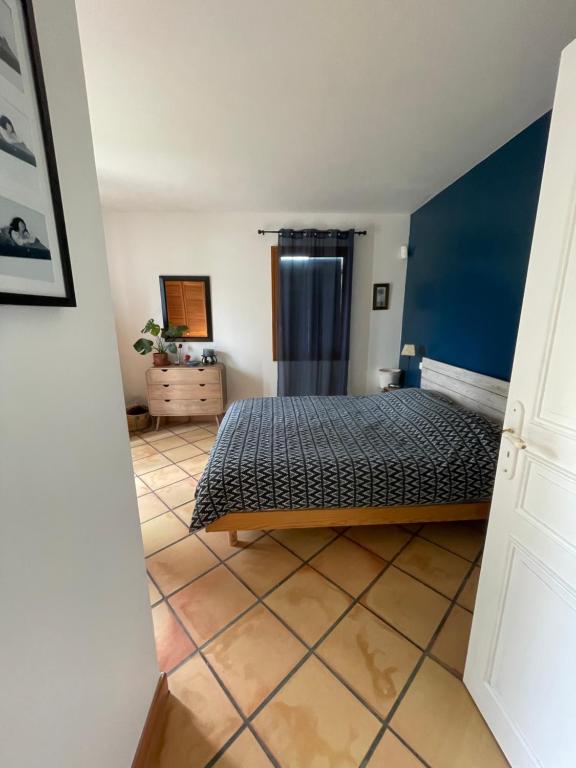 a bedroom with a bed and a blue wall at Villa avec piscine in Soyaux