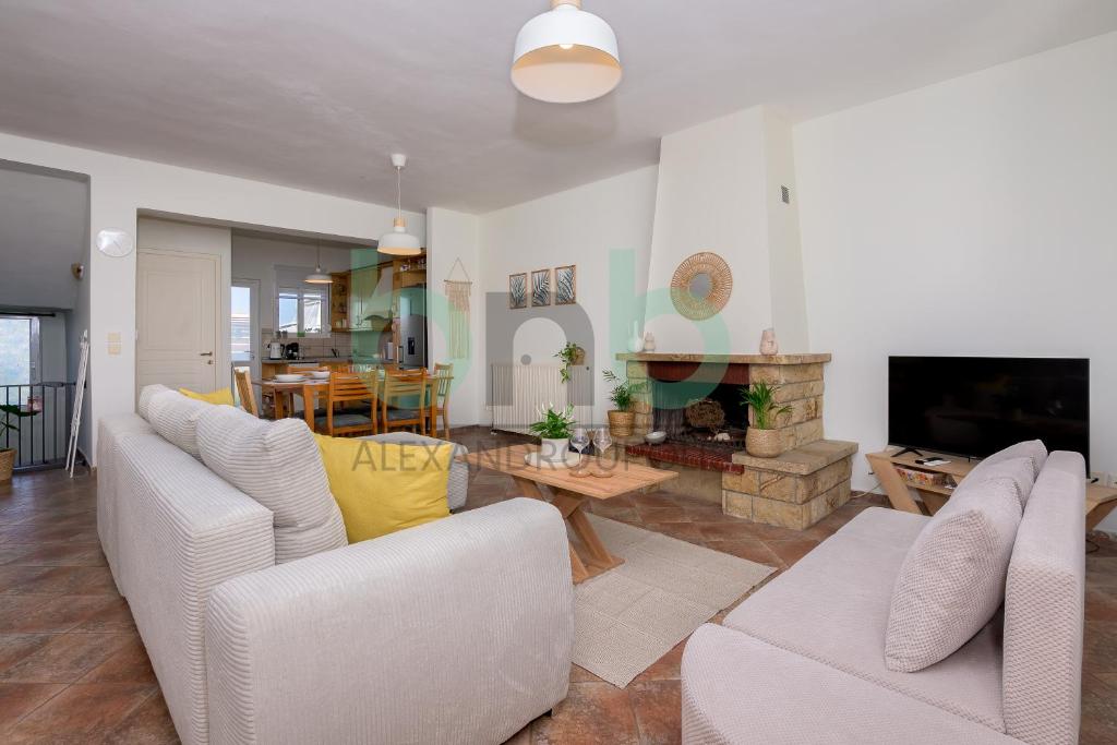 a living room with two white couches and a fireplace at Casa Cyra in Alexandroupoli