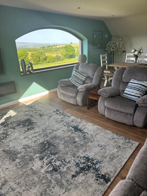a living room with two chairs and a large window at Corlea Studio in Dunwish