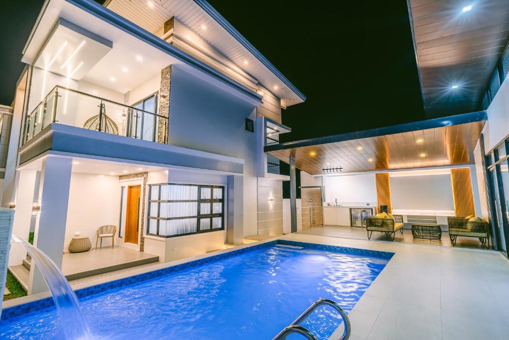 a house with a swimming pool in front of a house at Amethyst Bcd in Bacolod