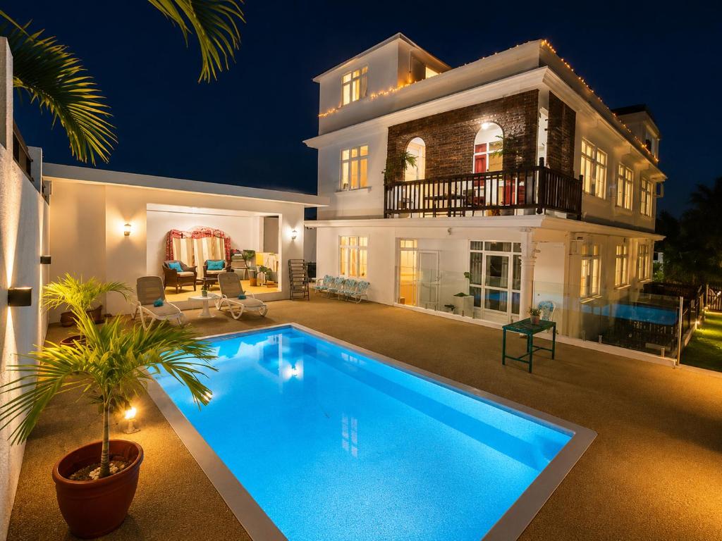 a large house with a swimming pool in front of it at Suntoo Villa Wind & Kitesurf Accommodation in La Gaulette