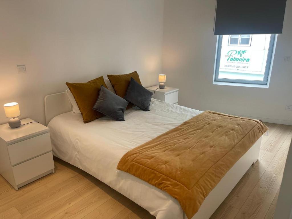 a bedroom with a bed with two night stands and two lamps at Ria & Mar Collection I in Aveiro