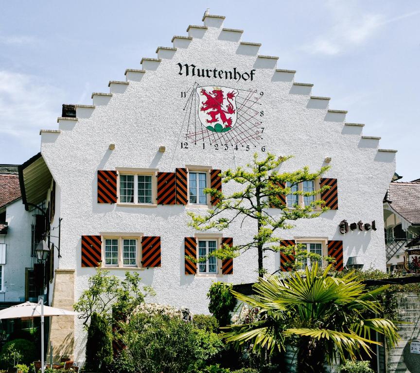 a white building with a crest on it at Hotel Murtenhof & Krone in Murten