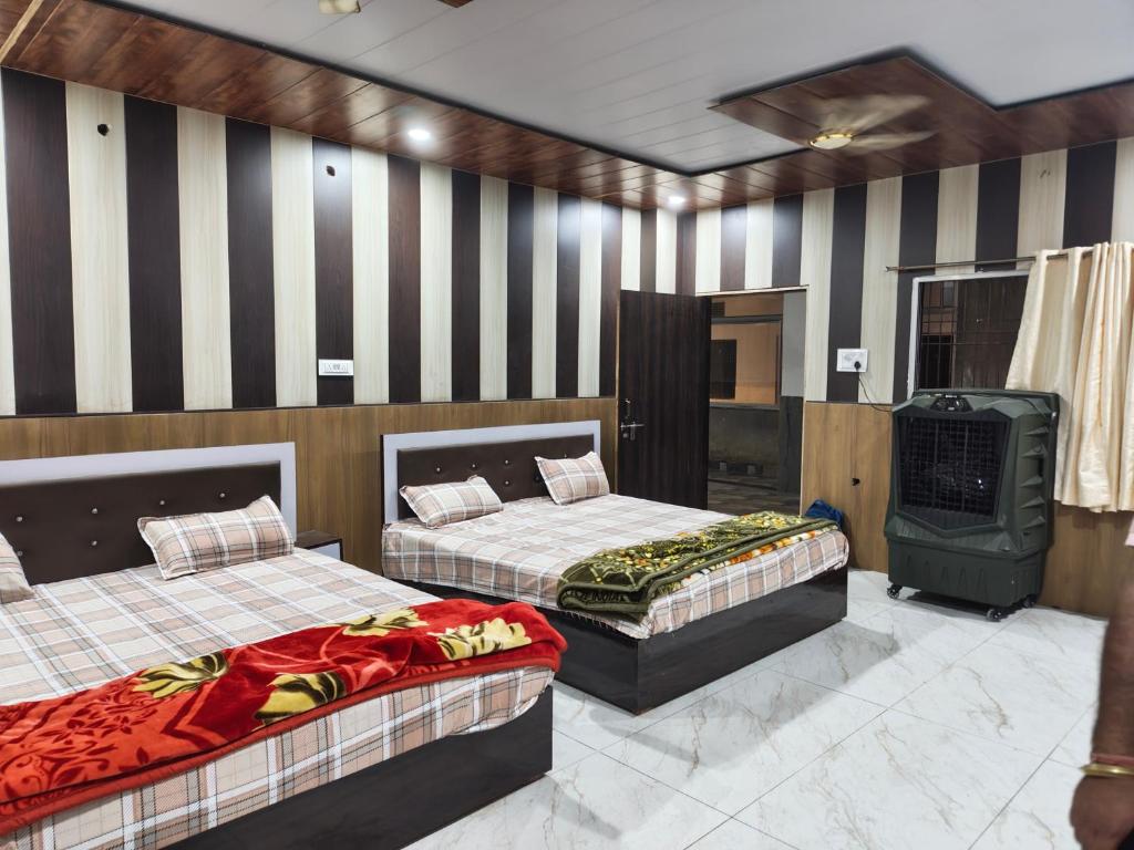 two beds in a room with striped walls at Madan Usha Resort in Chitrakoot