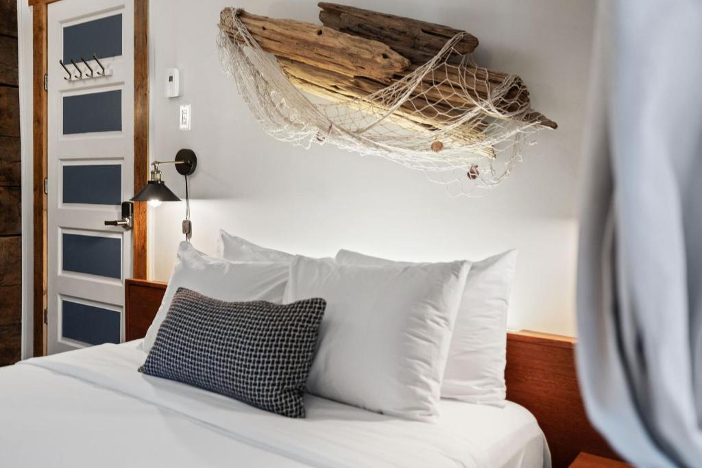 a bedroom with a bed with white pillows and a driftwood ceiling at Le Ricochet Urbain in Quebec City