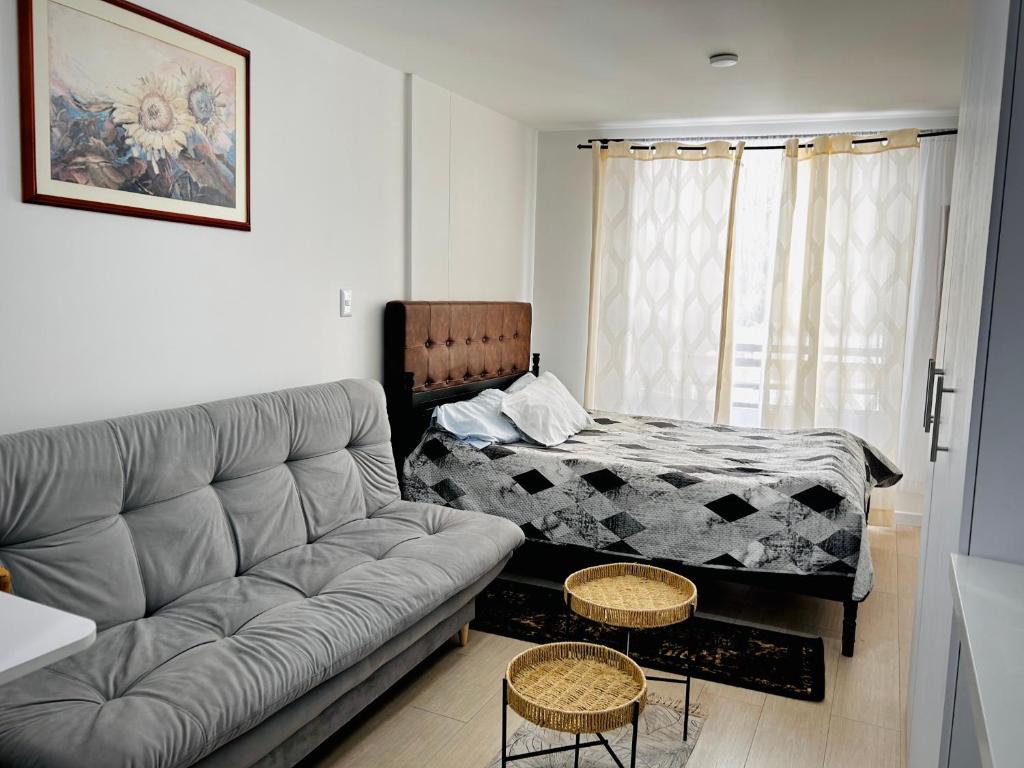 a living room with a couch and a bed at Apartamento floral in Tunja
