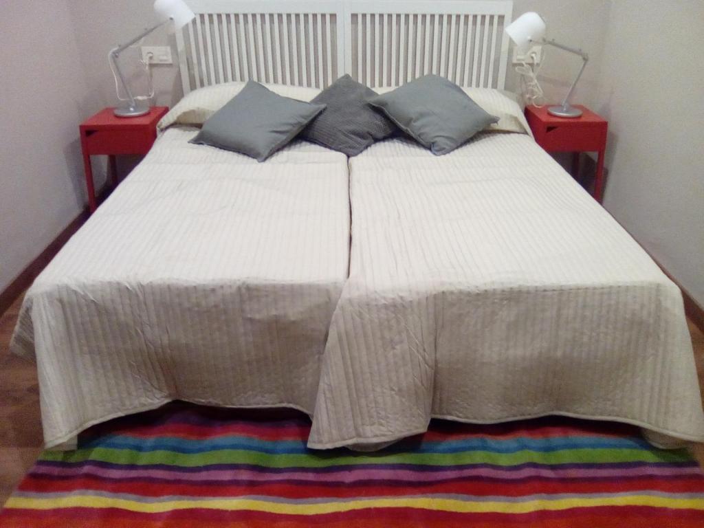 Una cama blanca con dos almohadas encima. en Jan&Joan Apartment en Bilbao