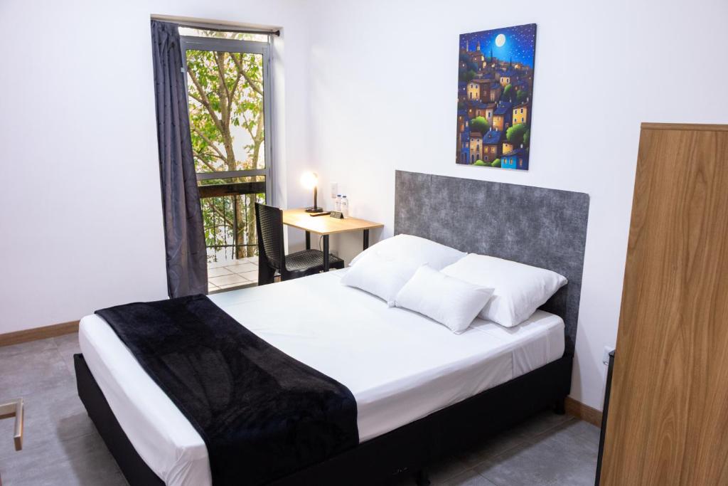 a bedroom with a bed and a table and a window at Komfort House Premium in Medellín