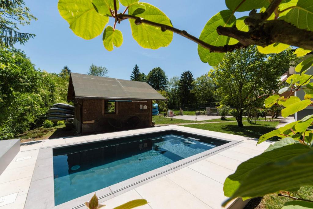 a swimming pool in a yard with a dog house at Adventure Cottage with pool and big garden in Bled