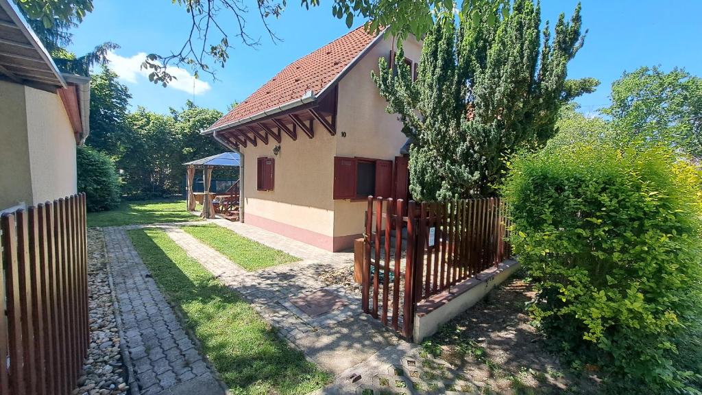 a house with a fence in front of a yard at Relax II. Vendégház in Dunapataj