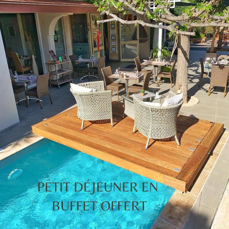 a patio with chairs and a table and a pool at Hôtel Beau Soleil in Le Lavandou