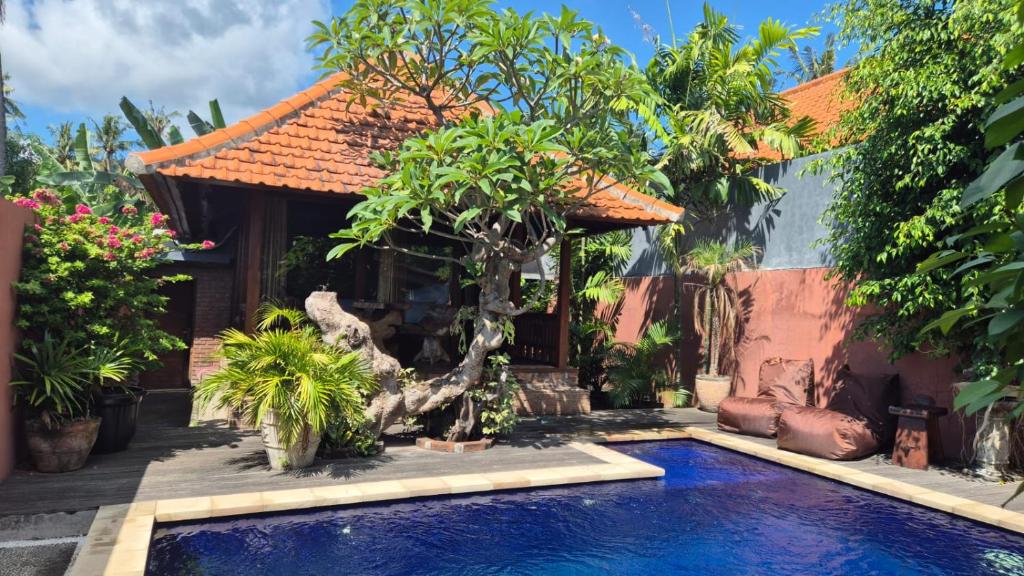 a swimming pool in front of a house with trees at Villa Intan 2 in Amed
