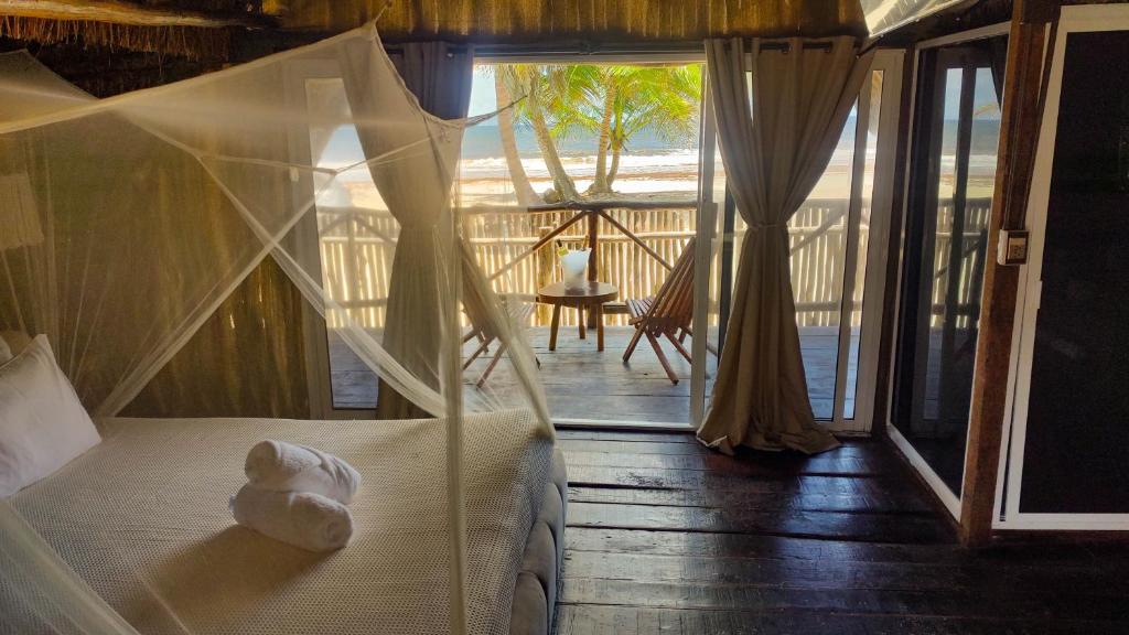 a bed in a room with a view of the ocean at Hotel Boutique Sylvie in Mahahual