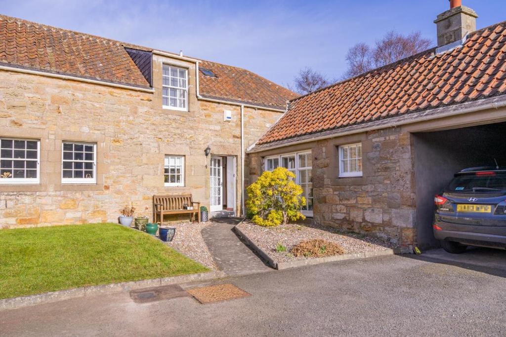 a brick house with a car parked in the driveway at 3 Bed in Kingsbarns oc-k30925 in Kingsbarns
