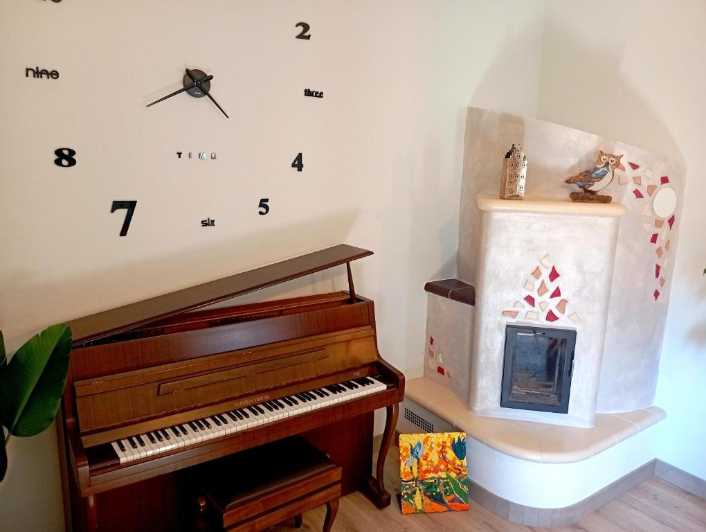 a room with a piano and a clock on the wall at I Mosaici Guesthouse in Ronco Scrivia