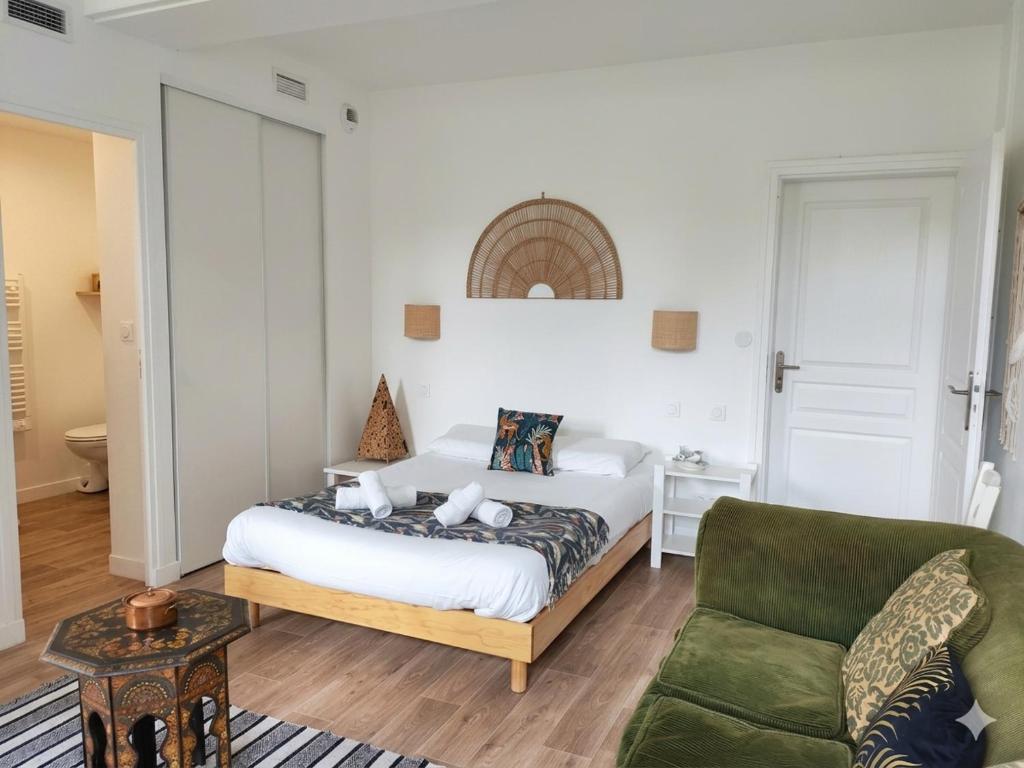 a bedroom with a bed and a green couch at Appart'Hôtel Bellevue in Bayonne