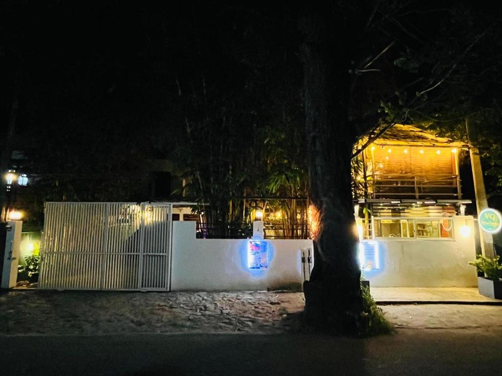 a building with a fence and a tree at night at Eightyseven guest and restaurant in Badulla