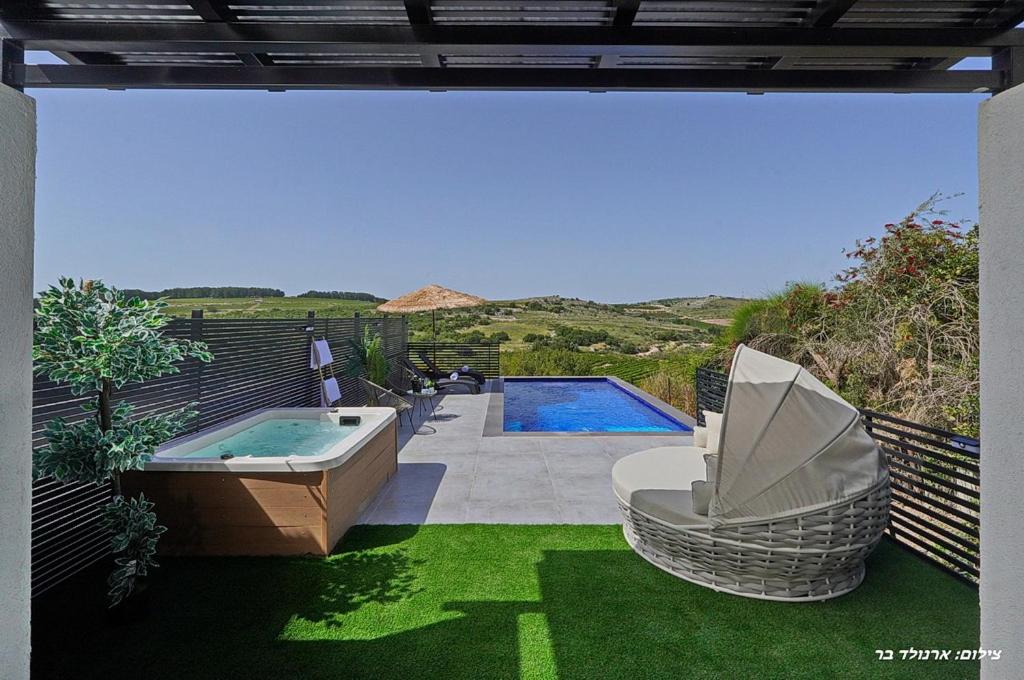 a backyard with a swimming pool and a hot tub at Sagit luxury suites in Elqosh