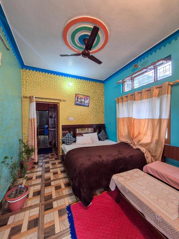 a bedroom with two beds and a ceiling fan at Dev Palace in Uttarkāshi
