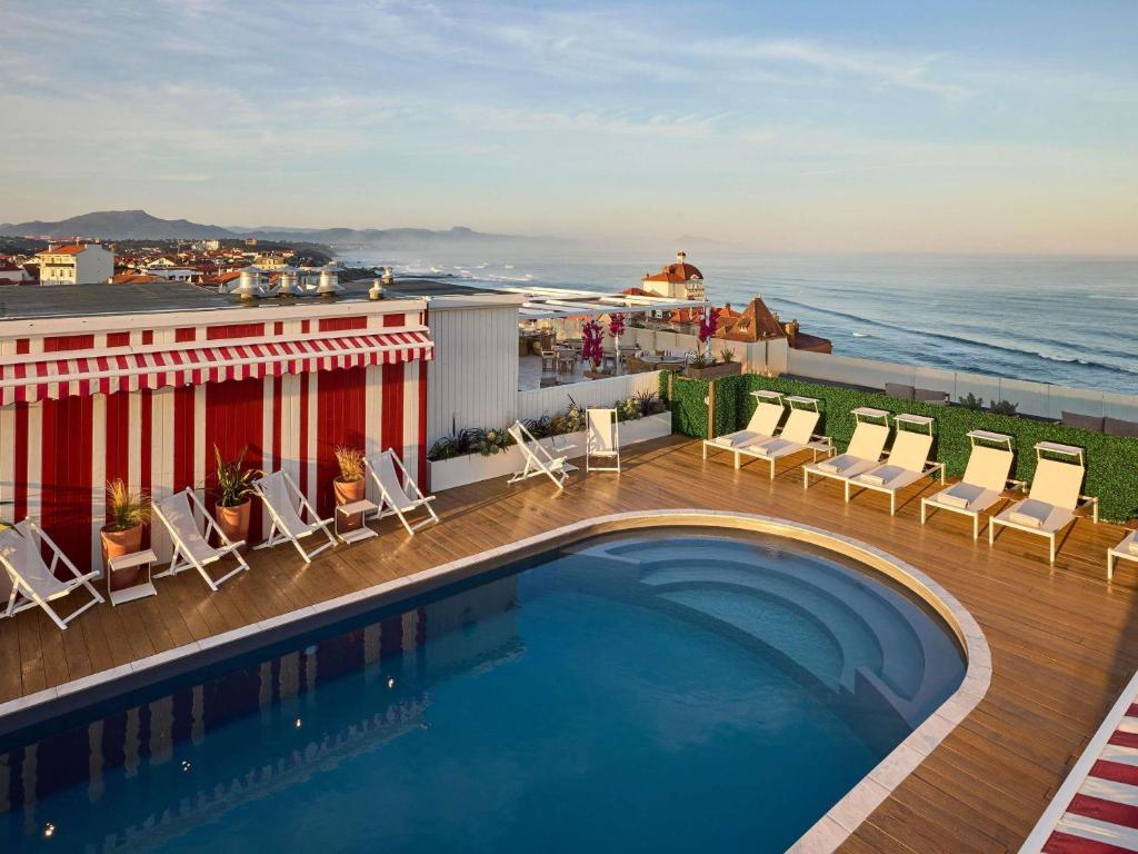 a swimming pool on top of a building with the ocean at Le Talaia Hôtel & Spa Biarritz - MGallery Collection in Biarritz