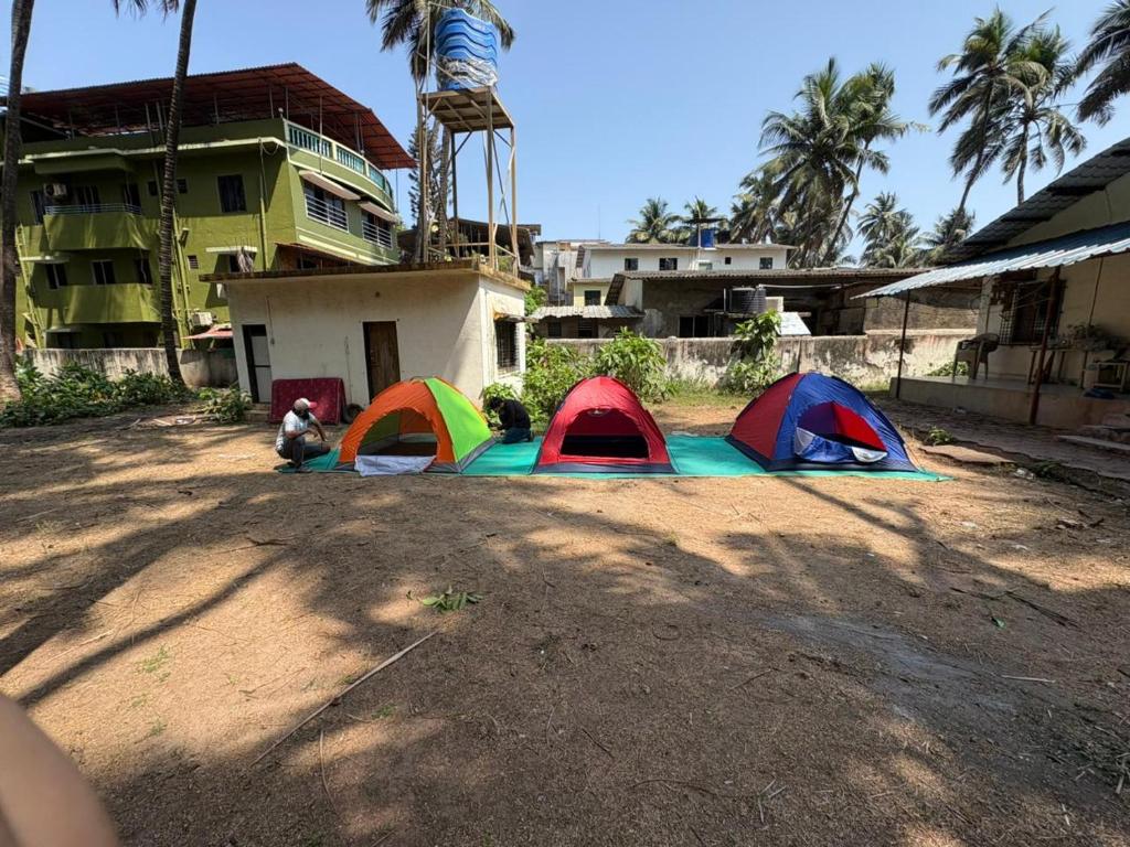a group of tents on the ground in front of a building at Sea front tent house in Murud