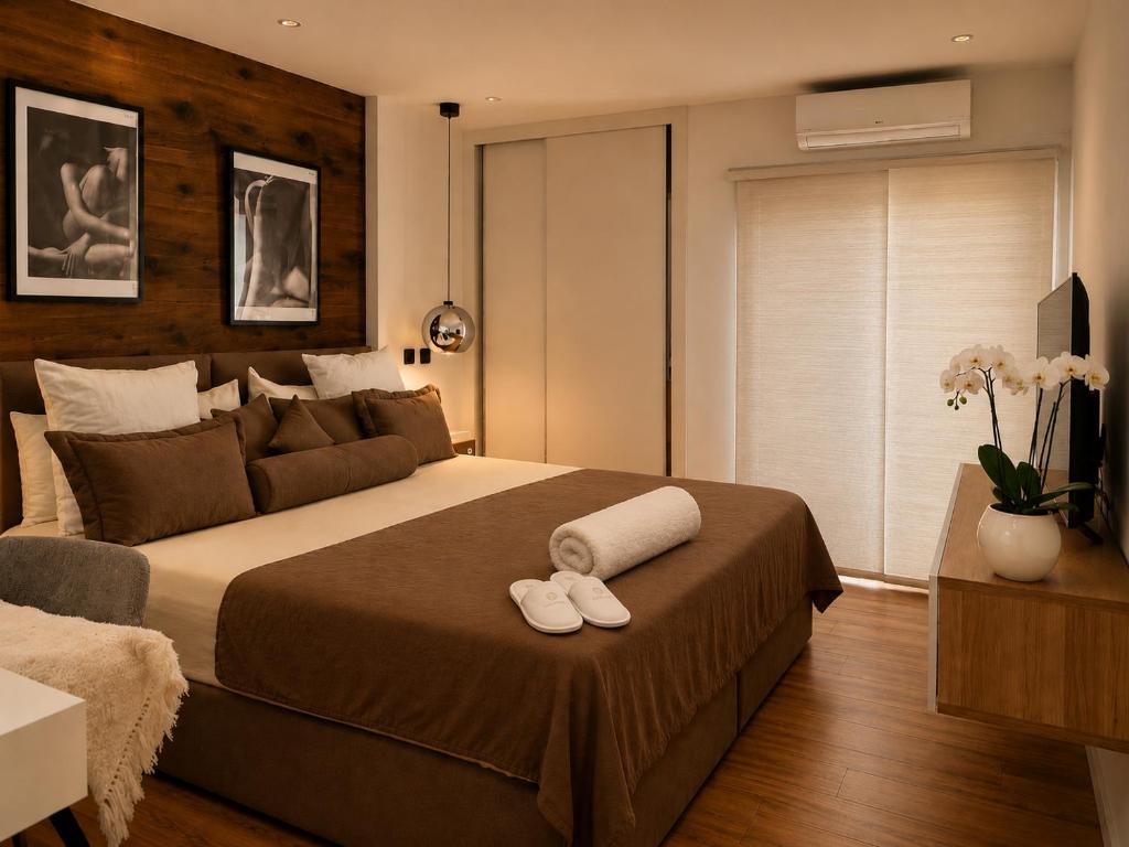 a bedroom with a large bed with two slippers on it at Luxe-Design Imperio II- Petit Déjeuner 5min de la Mer in Praia