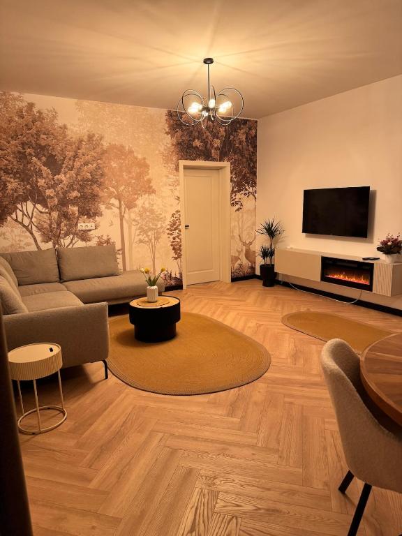 a living room with a couch and a tv at Aura Home - Livezeni Hiperbara in Livezeni